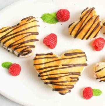 three heart shaped cream puff with chocolate drizzle
