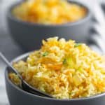 un plato con arroz con zanahoria y un tenedor