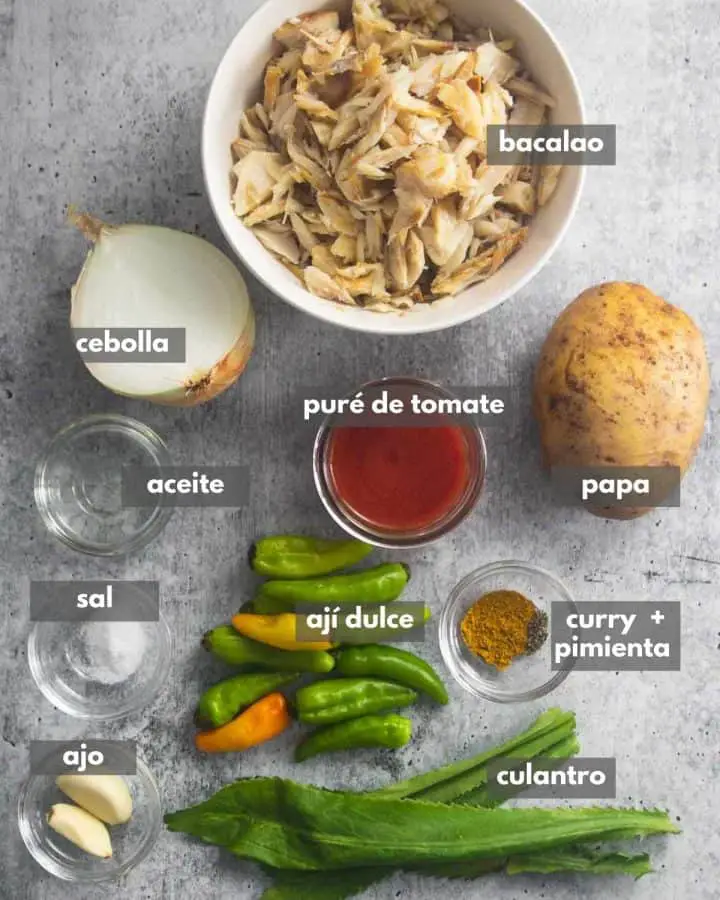 vista superior de ingredientes (bacalao, culantro, especias, cebolla, papa, ajíes)