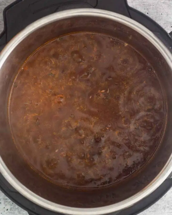 top view of an instant pot with beans sauce thickening