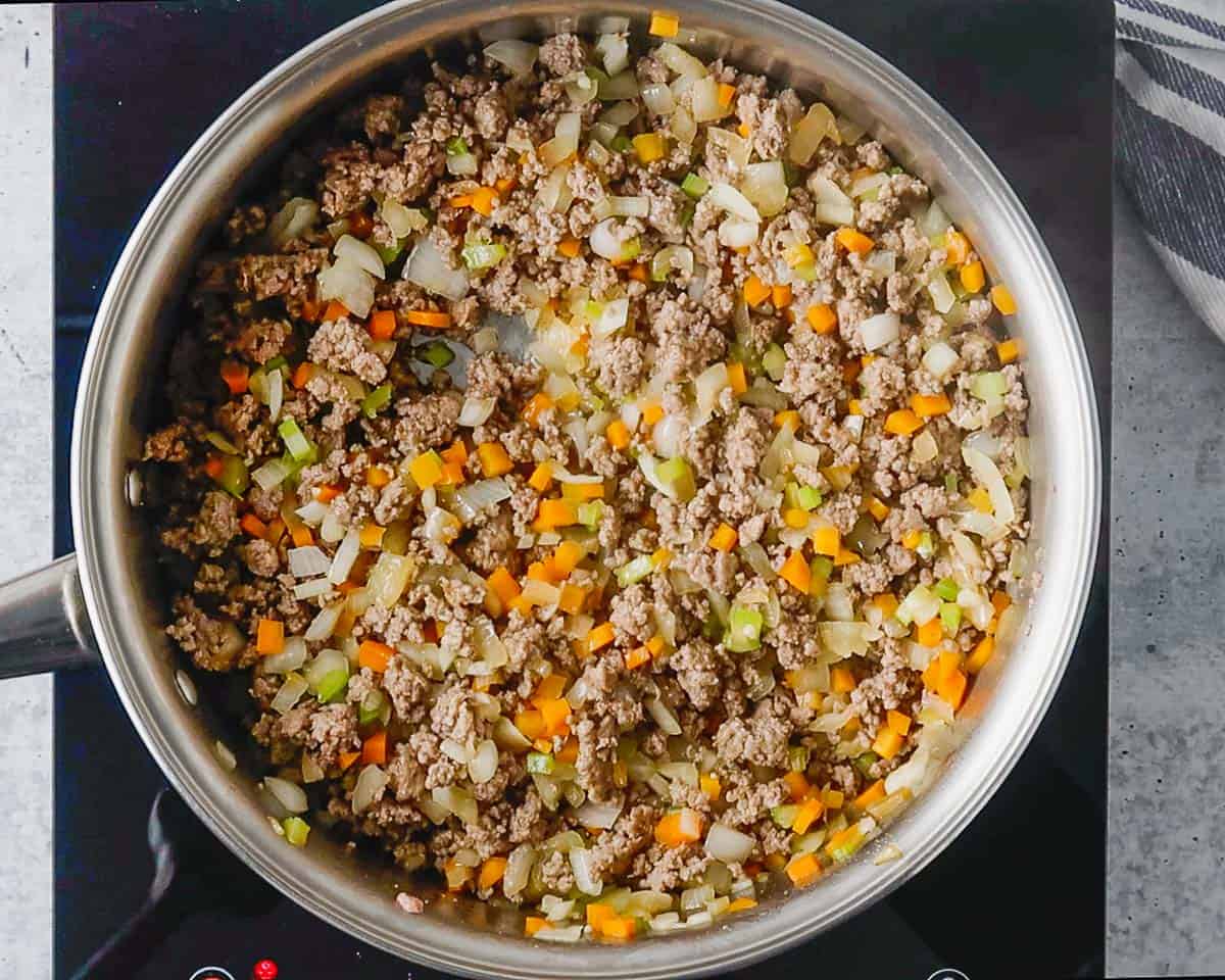 Browned ground beef and sautéed veggies in a skillet.
