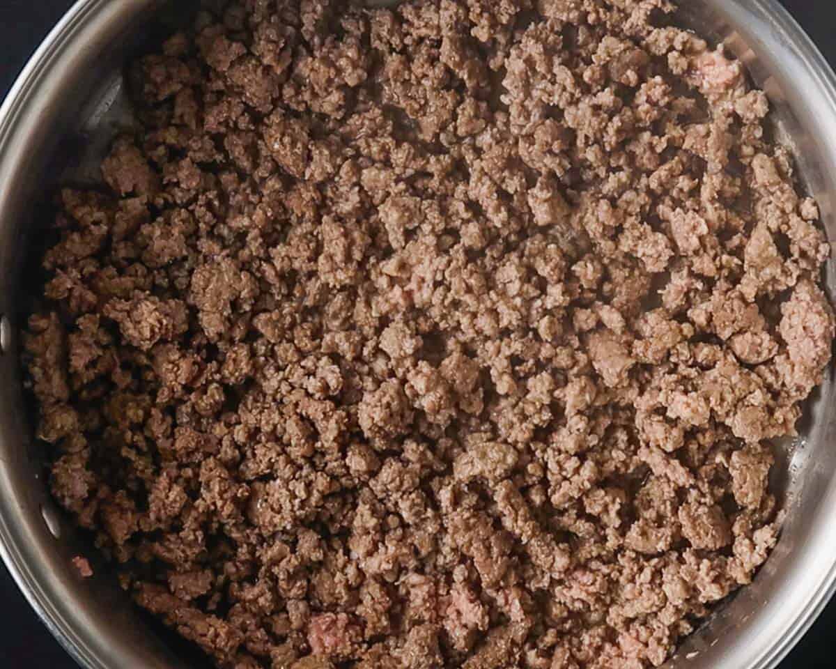 A top view of a skillet with browned ground beef.