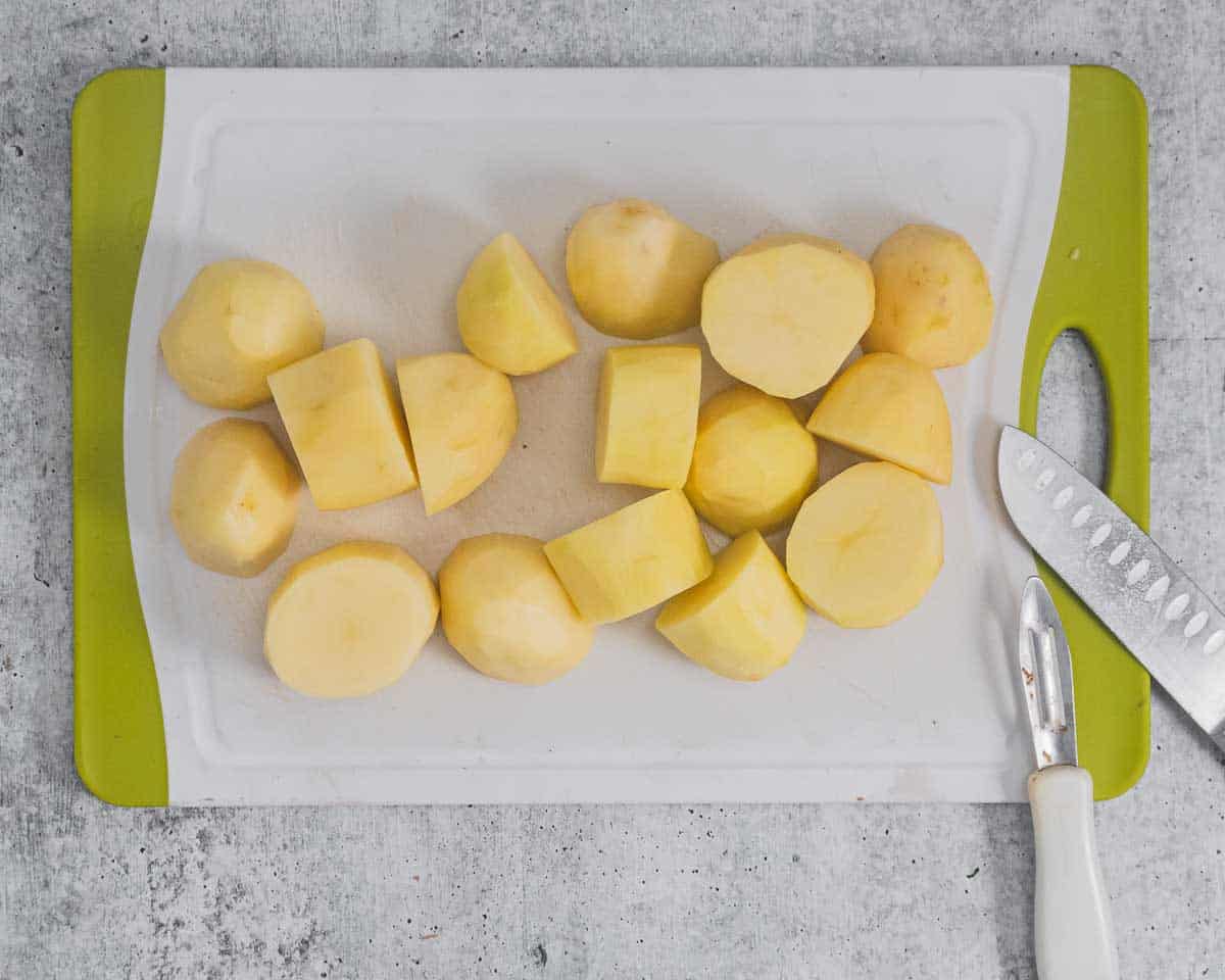 Peeled and chopped russet potatoes on a chopping board.