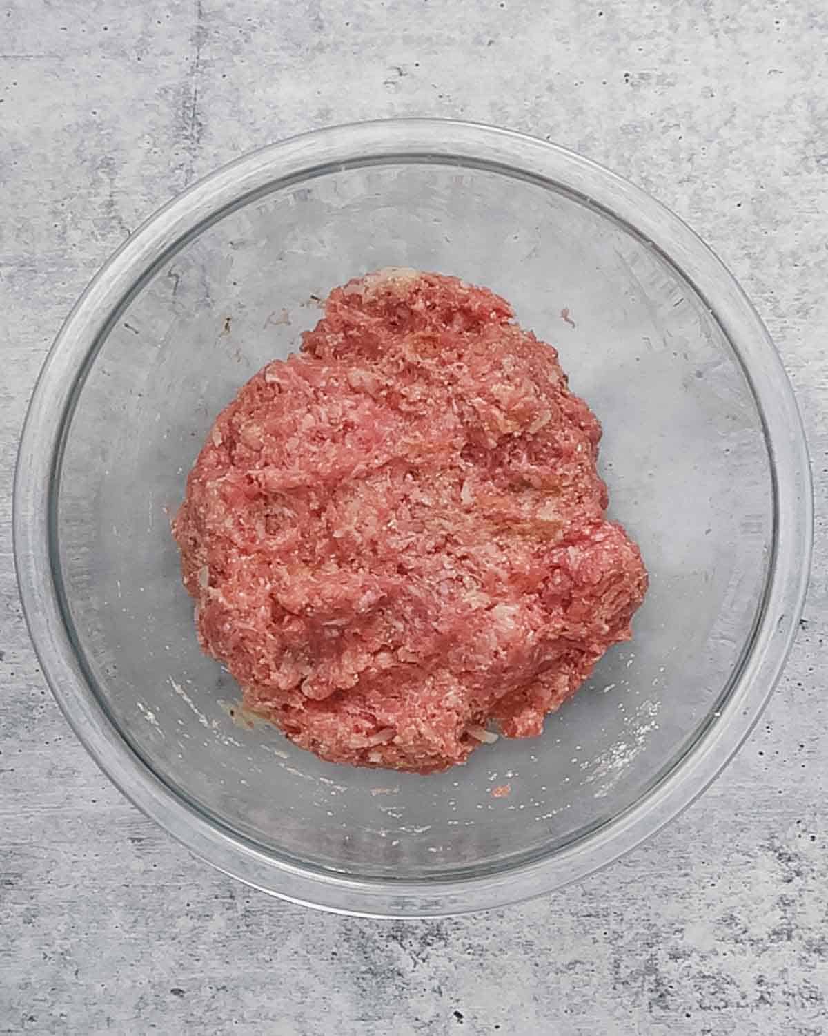Meatballs ingredients in a mixing bowl mixed.