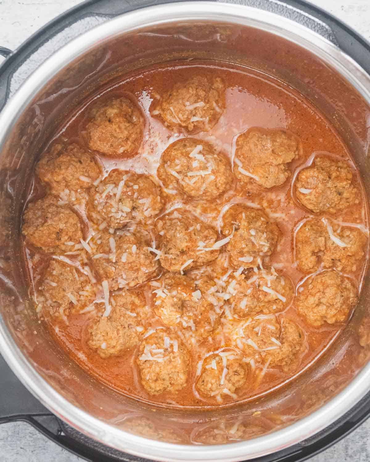 Cooked meatballs in sauce inside an Instant Pot.