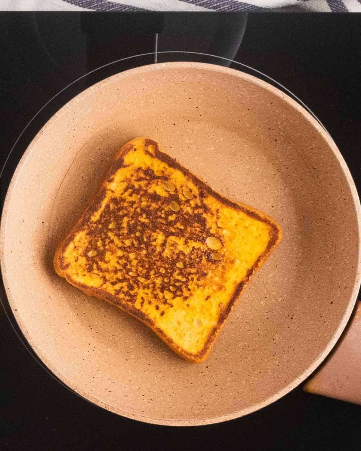 A golden brown french toast in a frying pan.