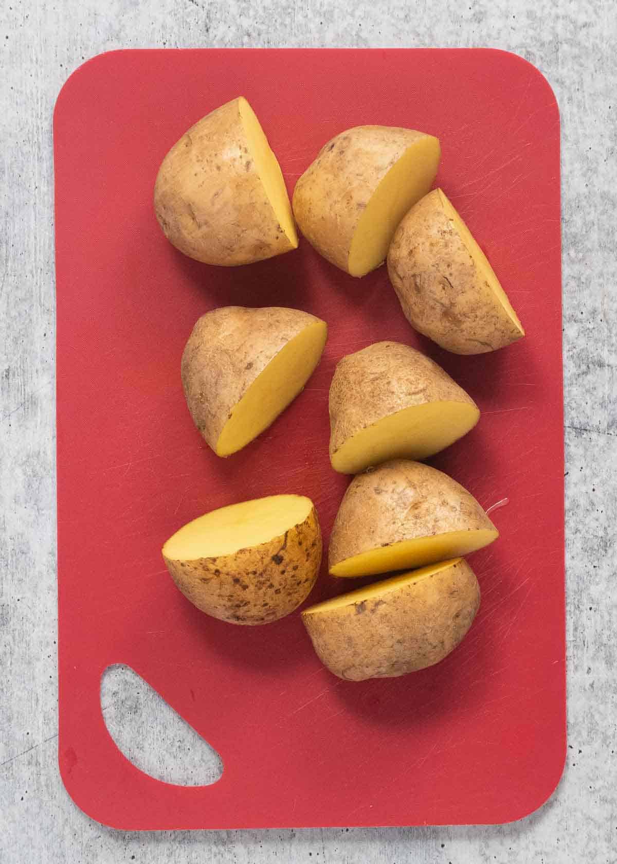 A top view of chopped potatoes on a chopping board.