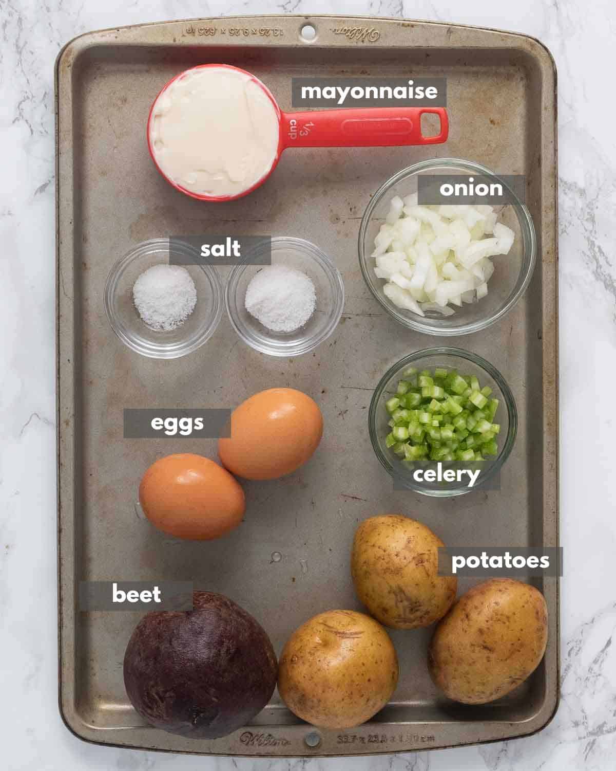 A top view of a ingredients portioned for making potato and beets salad.