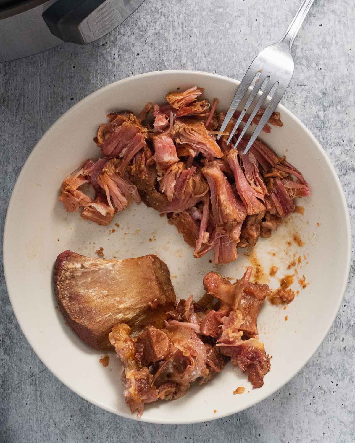 A plate with shredded ham meat from bone.