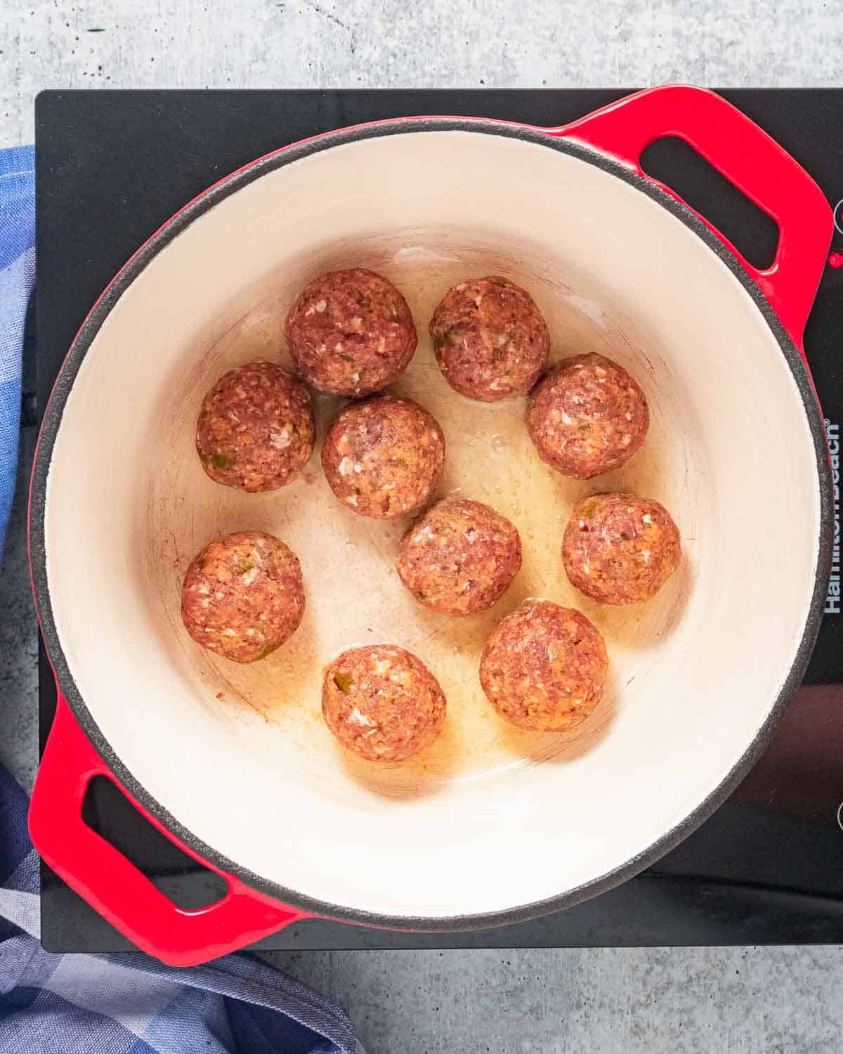 Meatballs in a Dutch oven before browned.