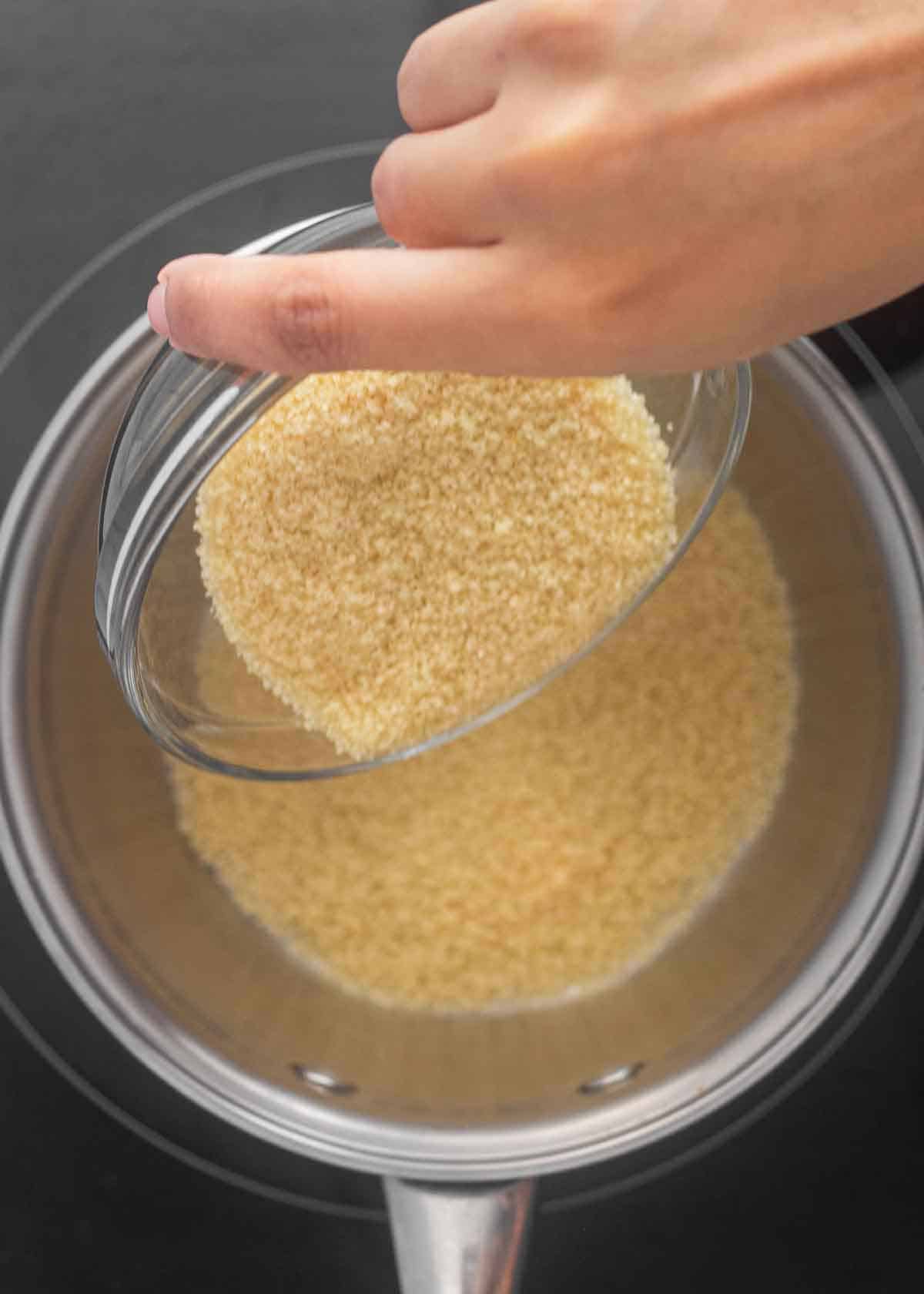 Adding brown sugar into a saucepan.