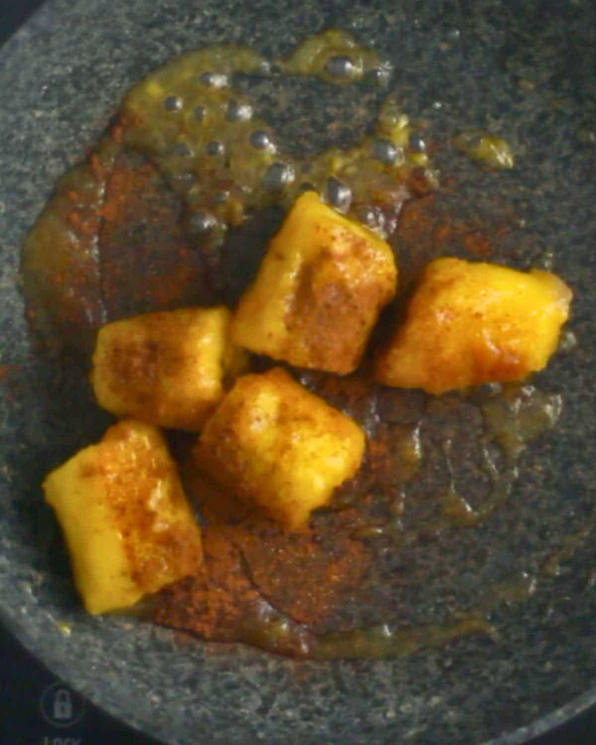 Ripe plantain with cinnamon and applesauce in a frying pan.